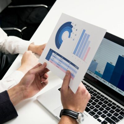 Geschäftsleute diskutieren Datendiagramme und Grafiken in einer modernen Büroumgebung.